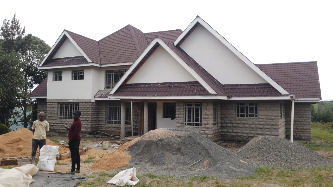 Completed stone family home with a tiled roof built by DecoHome Construction Ltd